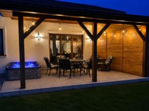 a patio with a table and chairs and a heater at American Dream Villa in Łazory