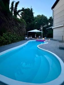 a large blue swimming pool next to a house at Villa Celeste -Flexrent Immobiliare Abissinia in Santa Maria di Scacciano