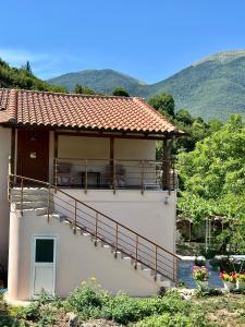 a white house with a balcony and mountains in the background at Magnus Appartments in Dukat