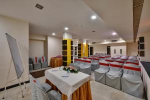 a room with rows of tables and chairs in it at Click Hotel Yuvraj in Surat