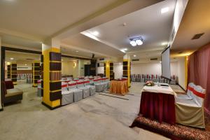a banquet hall with tables and chairs in a room at Click Hotel Yuvraj in Surat