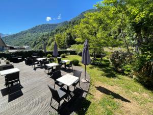 a group of tables and umbrellas on a deck at Logis Hôtel Le Central in Barèges