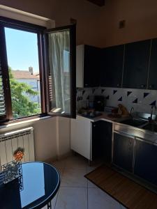 a kitchen with a table and a sink and a window at LOCAZIONE TURISTICA Camere De Vito in San Salvo
