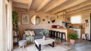 a living room with a couch and a kitchen at Jotwingia - Domki z Widokiem in Stare Juchy