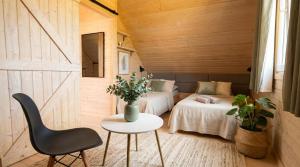 a bedroom with two beds and a table and a chair at Jotwingia - Domki z Widokiem in Stare Juchy