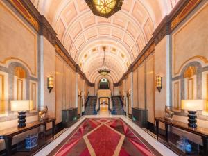a hallway with a large red rug in a building at Fairmont Peace Hotel on the Bund in Shanghai
