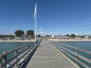 a wooden boardwalk leading to the beach with a pier at Feriengarten Dahme W 20 in Dahme +6 photos