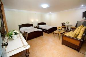a living room with two beds and a couch at El Centro Beach Resort Boracay in Boracay