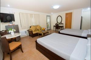 a bedroom with two beds and a living room at El Centro Beach Resort Boracay in Boracay