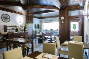 a restaurant with wooden ceilings and tables and chairs at River Hotel in Castel di Sangro