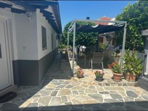 a patio with potted plants and an umbrella at Agathe Haus in Stavros