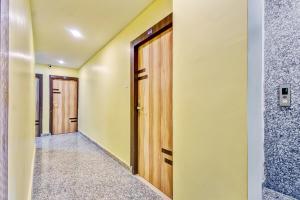 a corridor of a room with wooden doors at Hotel O DOWNTOWN INN in Kolkata