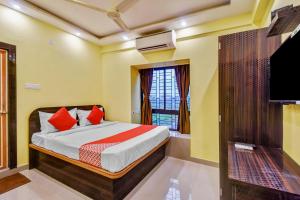a bedroom with a bed and a tv at Hotel O DOWNTOWN INN in Kolkata