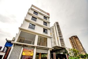 a tall white building with two tall buildings at Hotel O DOWNTOWN INN in Kolkata