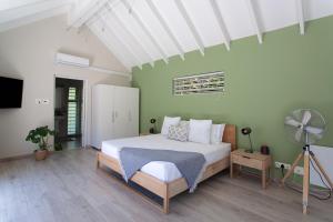 a bedroom with a white bed and a fan at The Barn Style Cottage in Cape Town +11 photos