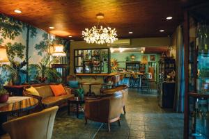 a restaurant with a couch and tables and chairs at The Bohemian Boutique Guesthouse in Tzaneen