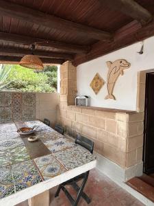 a dining room with a table and a wall at Il Villaggetto sul Mare in Favignana