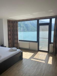 a bedroom with a large window with a view of the water at Casa Maria Dubova in Dubova