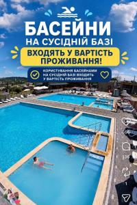 a large swimming pool with two people in it at ALLIANCE Hotel NEW 2025 -Breakfast and pool included in Solotvyno