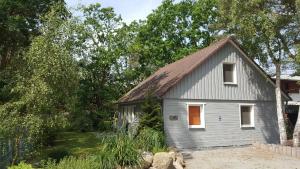 a small gray house with a red door at Wittower Heide 40-3 in Glowe