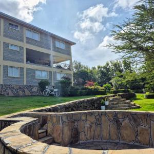 a building with a retaining wall in front of a yard at Hilltop Lakeview in Munyu