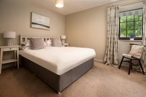 a bedroom with a large bed and a window at Town Farm Cottages Beadnell by Coast & Country Stays in Beadnell