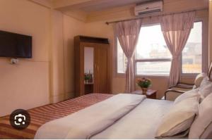 a bedroom with a large bed and a window at Hotel Kamal in Kathmandu