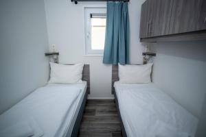 two beds in a small room with a window at Chaletpark Petzen in Feistritz ob Bleiburg