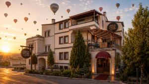 a group of hot air balloons flying over a building at Rocca Stone House in Göreme