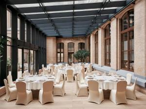 a room with white tables and chairs and windows at AC Hotel by Marriott Wroclaw in Wrocław