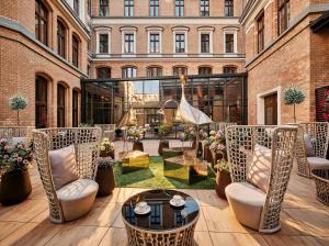 a patio with chairs and tables and a building at AC Hotel by Marriott Wroclaw in Wrocław