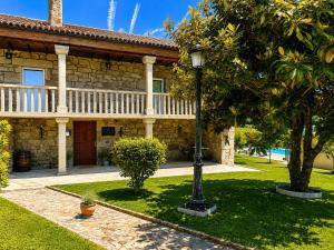 a stone house with a porch and a street light at Casa Ravel in Silleda