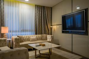 a living room with a couch and a flat screen tv at FASQ Hotel in Nouakchott