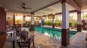 a swimming pool in a resort with tables and chairs at The Sierra - By The Lake in Udaipur