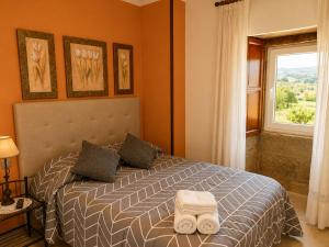 a bedroom with a bed with two towels on it at Casa Ravel in Silleda +31 photos