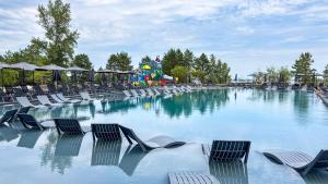a large swimming pool with chairs and a playground at Morewell Resort&SPA in Tolokun
