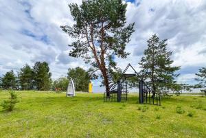 a tree and a swing set in a field at Morewell Resort&SPA in Tolokun