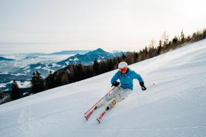 a man is skiing down a snow covered slope at Chaletpark Petzen in Feistritz ob Bleiburg