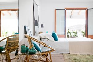 sypialnia z dużym łóżkiem i niebieskimi poduszkami w obiekcie CBbC Suites Port Vell w mieście Ibiza