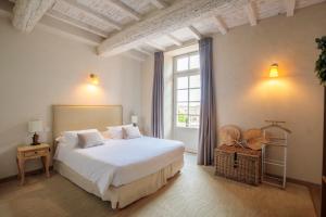 a bedroom with a white bed and a window at Boutique Hôtel La Villa Montesquieu & sa piscine in Laudun +33 photos