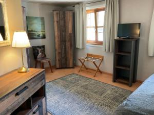 a bedroom with a bed and a tv and a window at Haus Louise in Reit im Winkl