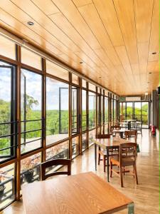 a restaurant with tables and chairs and large windows at Starhomes Hotel & Cafe in Tarlac