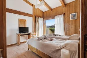 two beds in a room with a tv and a window at Pirin Golf Villa in Bansko