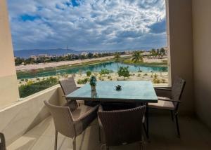 a table and chairs in a room with a large window at Segal 2 Hawana Salalah Forest Island in Salalah
