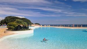 a woman is swimming in a swimming pool at Lighthouse Apartment in Luz +32 photos