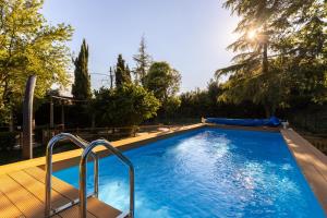 a large swimming pool with a wooden deck and a blue pool at -Piscina privata- 10 posti letto, Wifi, AC, Garden in Ripatransone