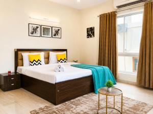 a bedroom with a bed with a blue blanket on it at BluO Lake View Studio - NewTown - Terrace Garden in Kolkata