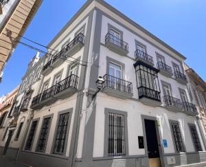 a white building with black balconies on a street at Iberflat San Gregorio in Seville