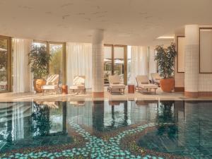 a swimming pool in a hotel with chairs and plants at Les Cimes Bleues in La Baule