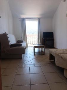 a living room with a couch and a table and a window at Sara in Kamenari